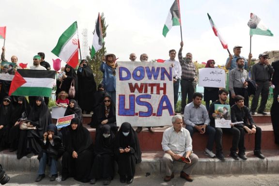 A man holds an anti-U.S. banner during a rally, as people gather in support of Gaza, in Tehran, Iran April 11, 2025.