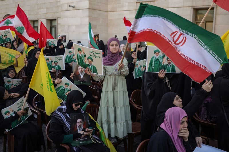 The image shows a gathering in Beirut, Lebanon, on April 22, 2026, where supporters paid tribute to Iran's late Supreme Leader Ali Khamenei and expressed support for his successor, Mojtaba Khamenei. 