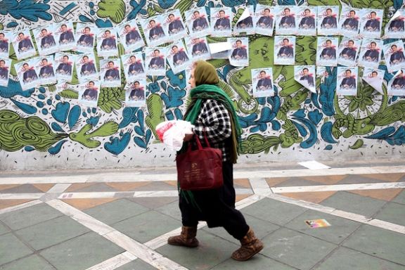 A woman walks past parliamentary election campaign posters in Tehran, Iran February 19, 2020.