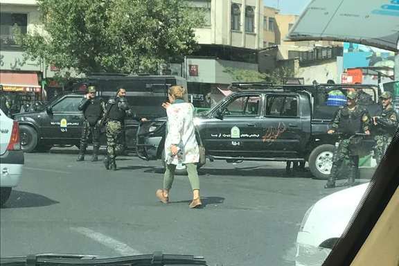 A woman without the mandatory hijab passing in front of security measures in Tehran on the eve of rallies for the anniversary of Mahsa Amini (September 2023)