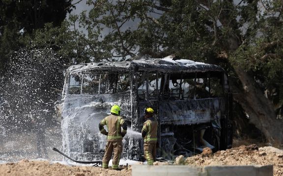 Firefighters work to extinguish a fire on a bus following a missile attack from Iran, in Herzliya, Israel, June 17, 2025.