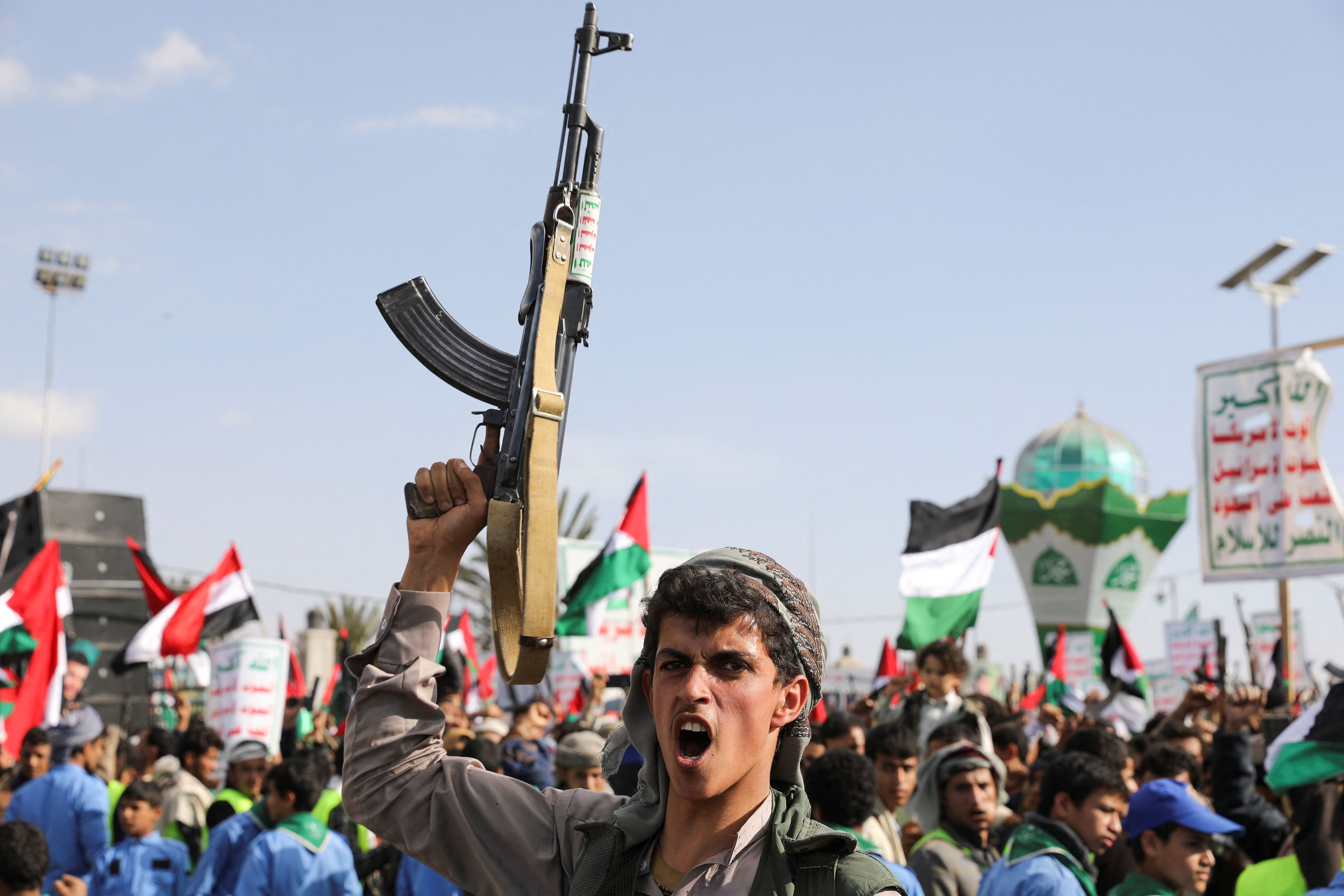 A man holds up a gun, as Houthi supporters rally to commemorate ten Houthi fighters killed by the US Navy in the Red Sea, in Sanaa, Yemen January 5, 2024. 