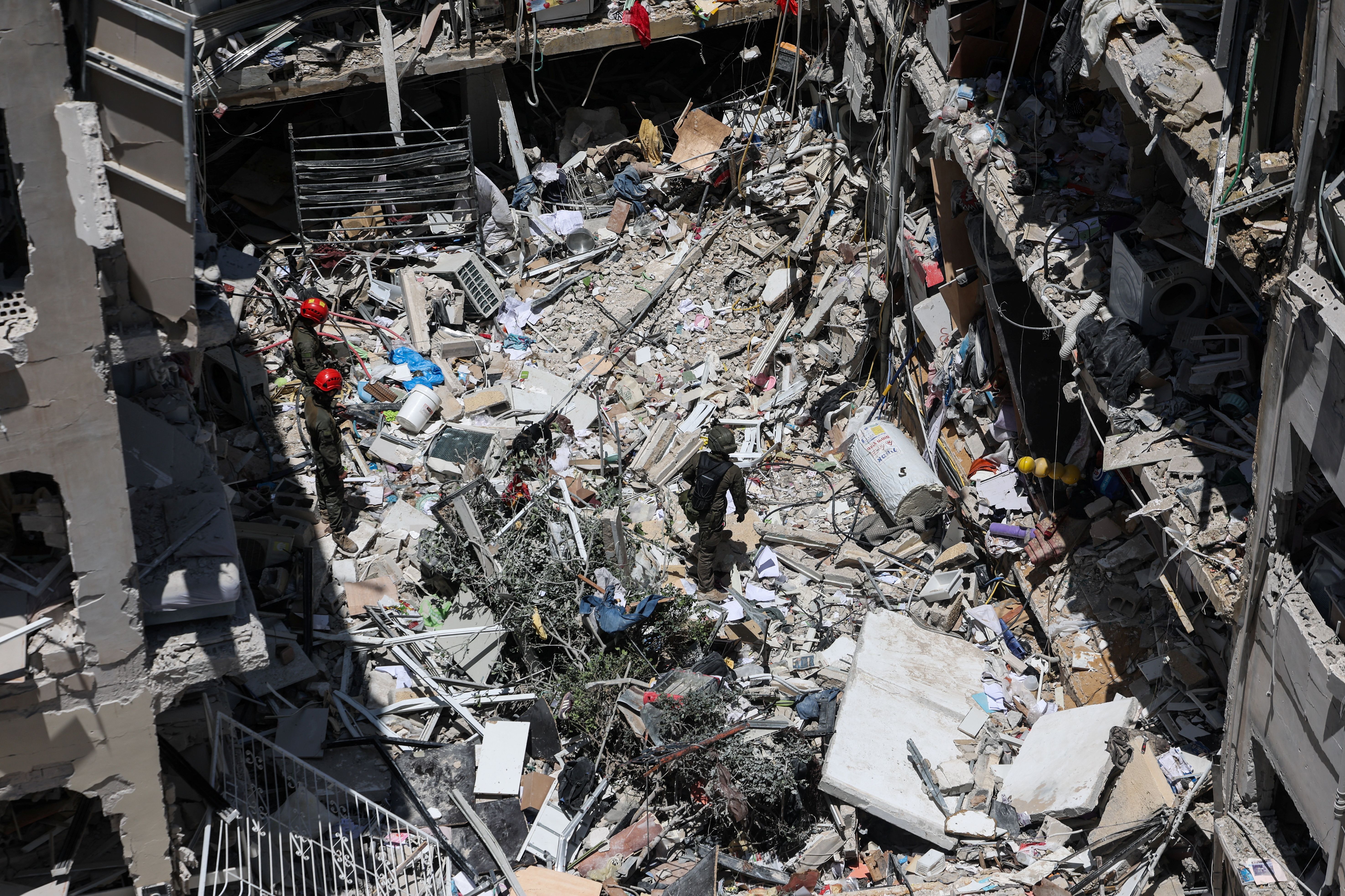 Rescue personnel work at an impact site following a missile attack from Iran, in Bat Yam, Israel, June 15, 2025. 