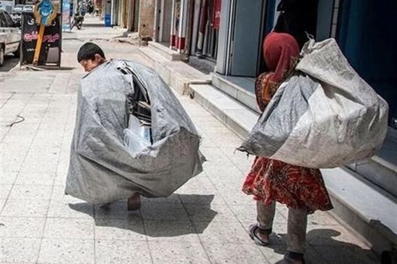 Afghan children laboring in Iran, carrying large, heavy sacks along the sidewalk