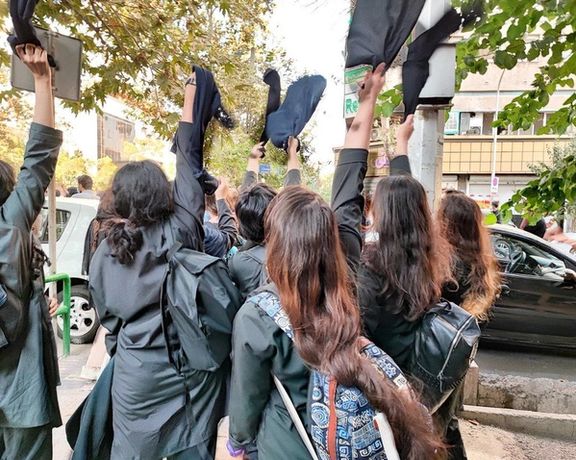 Schoolgirls removing their headscarves during protests in October