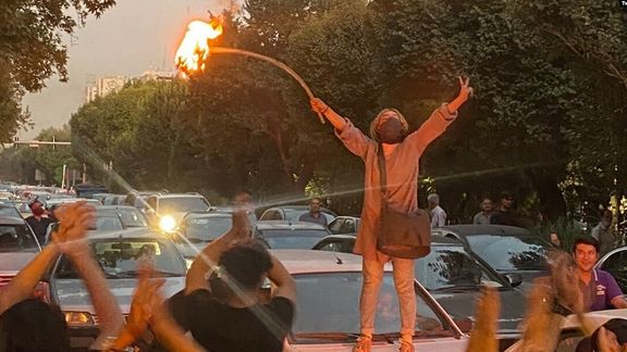 A young woman burning her headscarf during protests in Tehran on Sept. 19, 2022