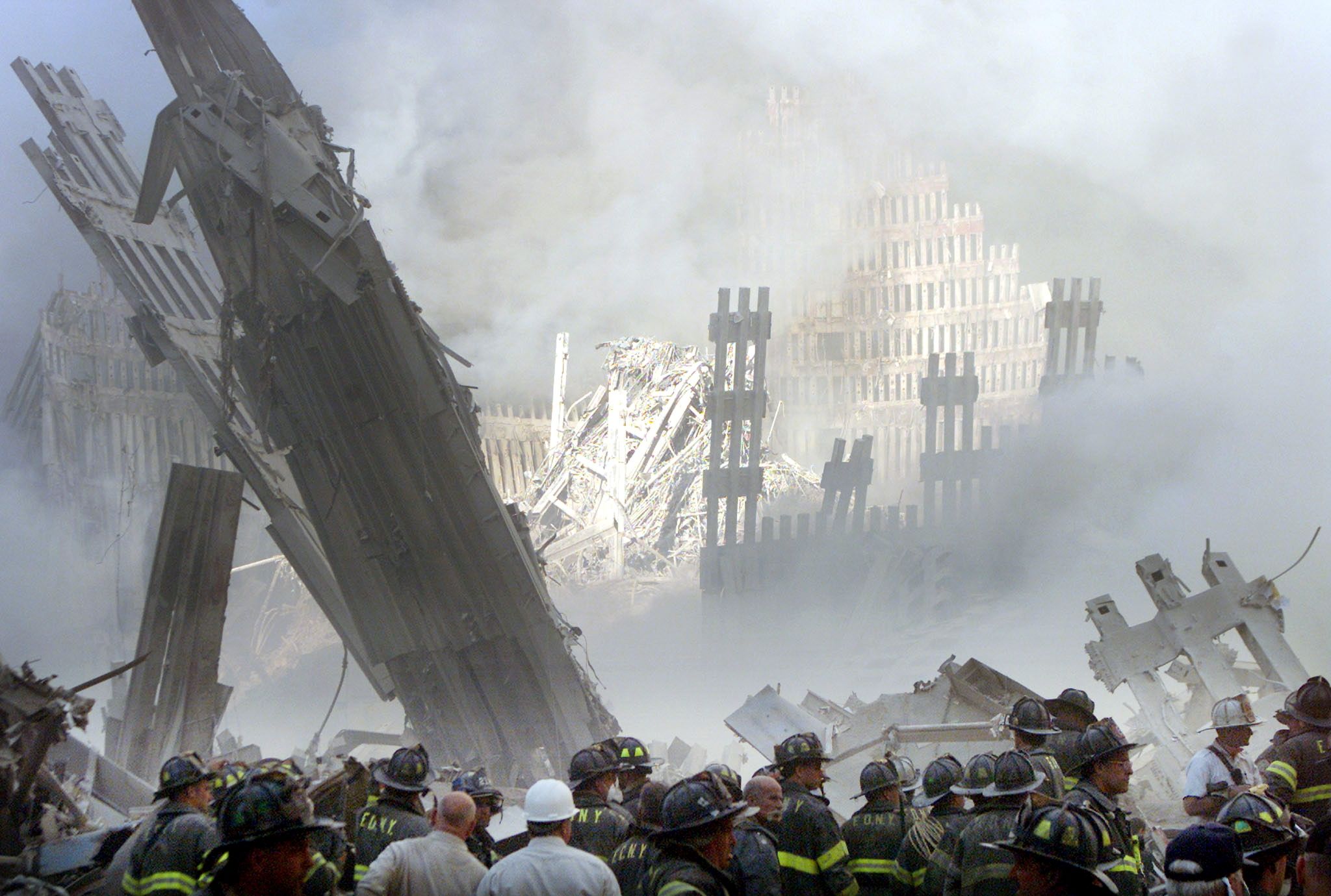 A group of firefighters stand on the street near the destroyed World Trade Centre in New York on September 11, 2001. 