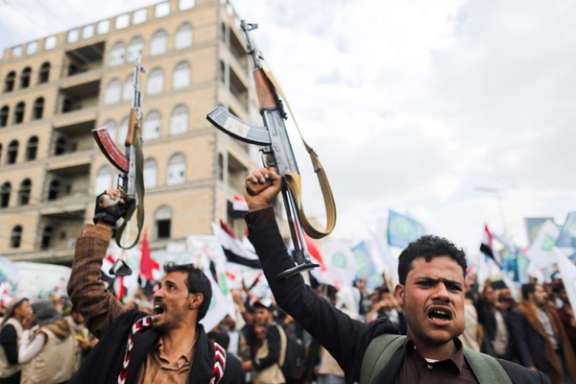 Supporters of Yemen's Houthis hold up their rifles as they rally to celebrate the seventh anniversary of the ousting of the government in Sanaa, 2021.
