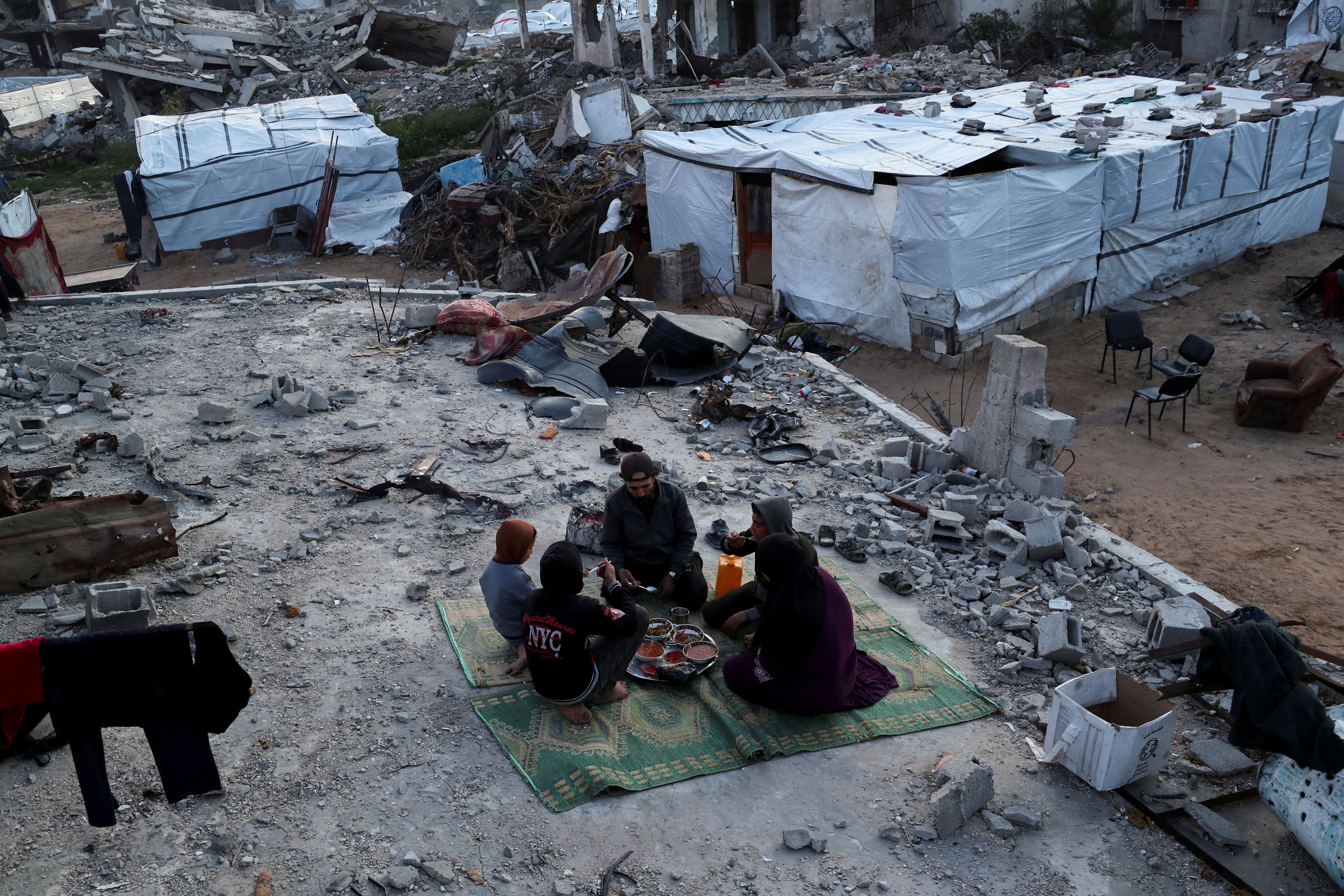 نمایی از یک خانواده فلسطینی در میان ویرانی‌های به‌‌جا مانده از درگیری‌ها در نوار غزه، ۱۲ اسفند