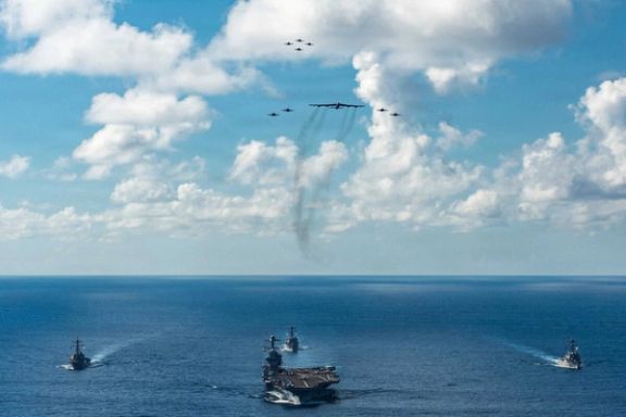 The US Navy’s Gerald R. Ford Carrier Strike Group sail towards the Caribbean Sea under F/A-18E/F Super Hornets and a US Air Force B-52 Stratofortress, in the Atlantic Ocean November 13, 2025.