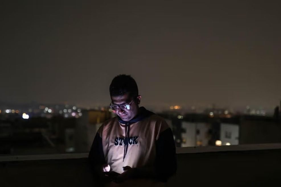An Iranian man, looks at his mobile phone, amid the US-Israeli conflict with Iran, in Tehran, Iran, March 15, 2026.