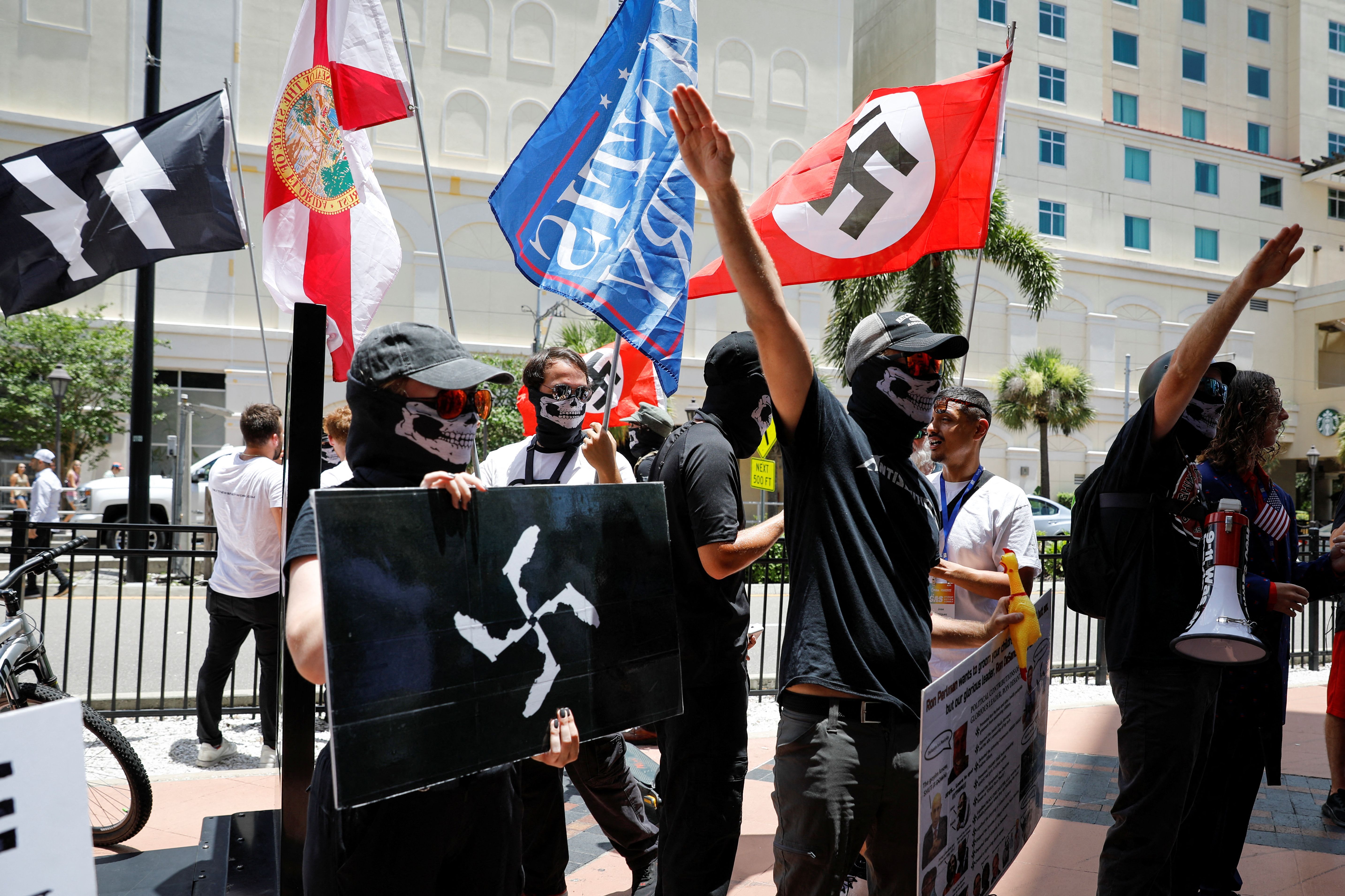 People wearing anti-semitic clothes wave Nazi flags, as they protest outside the Tampa Convention Center where Turning Point USA’s (TPUSA) Student Action Summit (SAS) is being held, in Tampa, Florida, US, July 23, 2022.