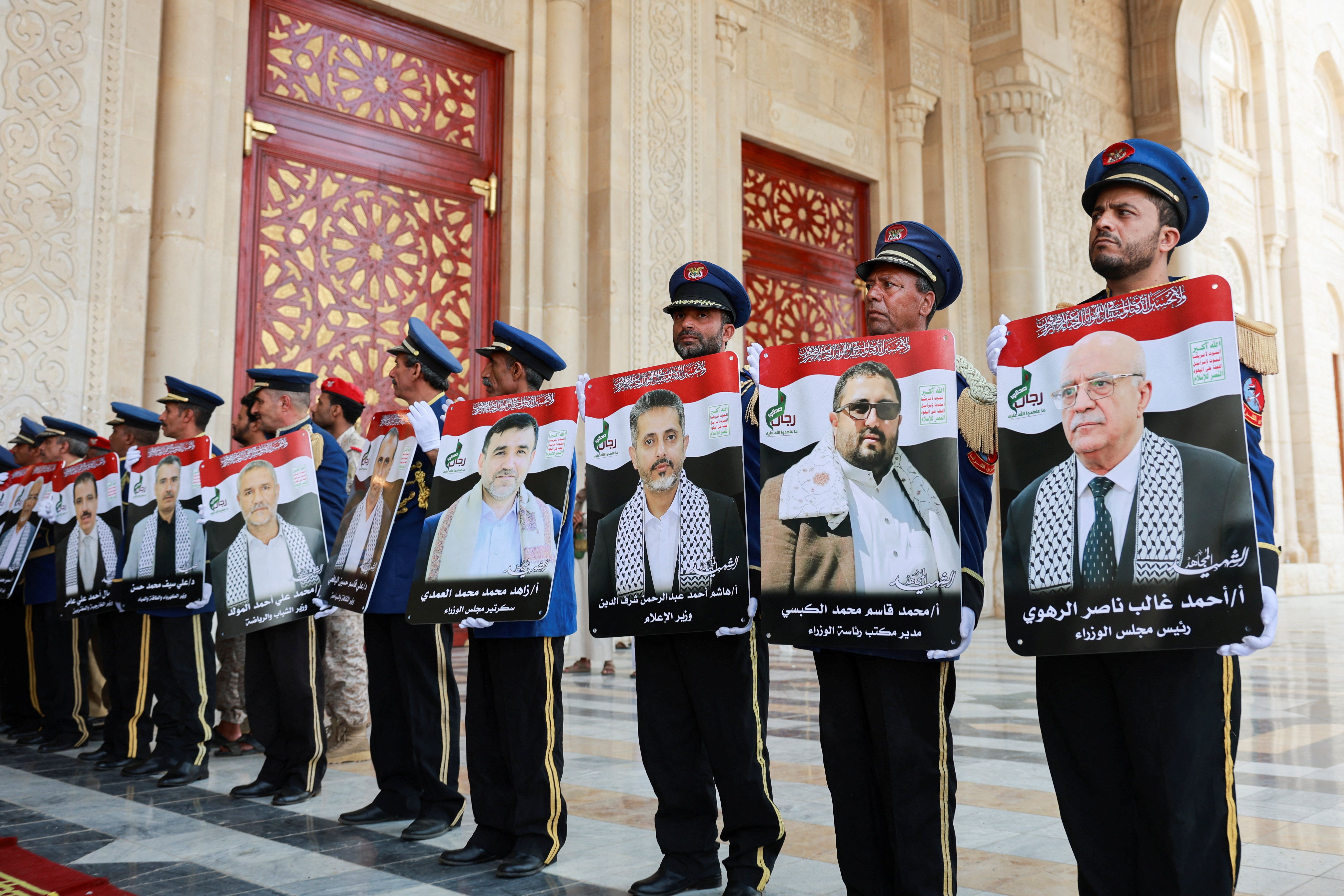 Honor guard hold photos of Prime Minister of Yemen's Houthi-led government Ahmed Ghaleb Al-Rahwi and other Houthi government officials killed in an Israeli strike, during a funeral procession in Sanaa, Yemen September 1, 2025. 