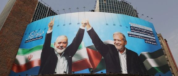 A billboard with a picture of assassinated Hamas chief Ismail Haniyeh and Iran's President, Masoud Pezeshkian, is displayed on a building in a street in Tehran, Iran, August 1, 2024.