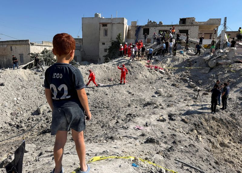 A child stands next to the rubble of a building damaged in an Israeli strike in Qennarit, southern Lebanon, June 20, 2026. 