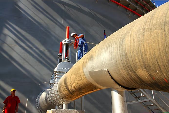 Workers service oil industry infrastructure in Iran