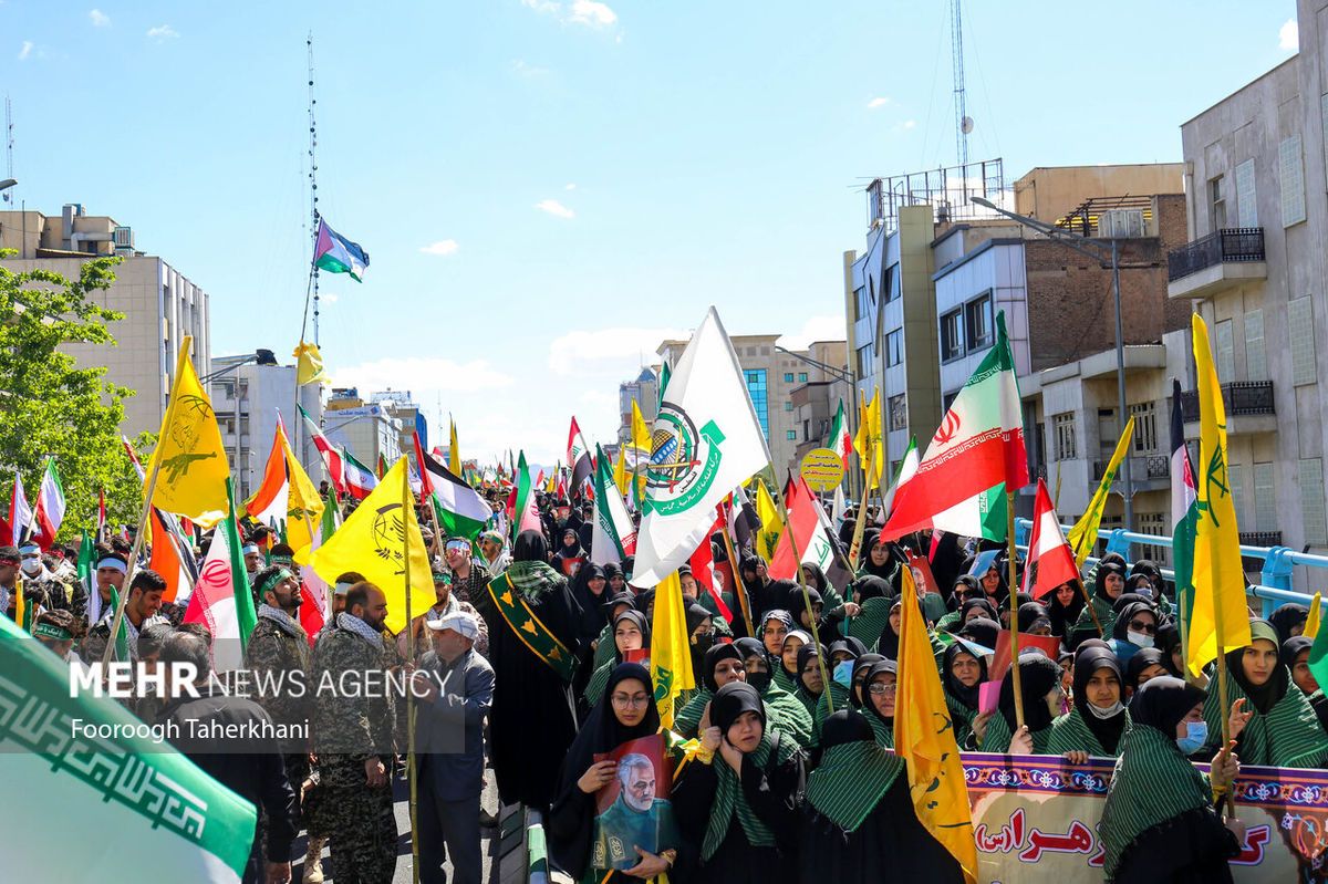Iranians carrying flags of Iran’s proxy militias during a regime-sponsored demonstration for Quds day in Tehran on April 14, 2023 
