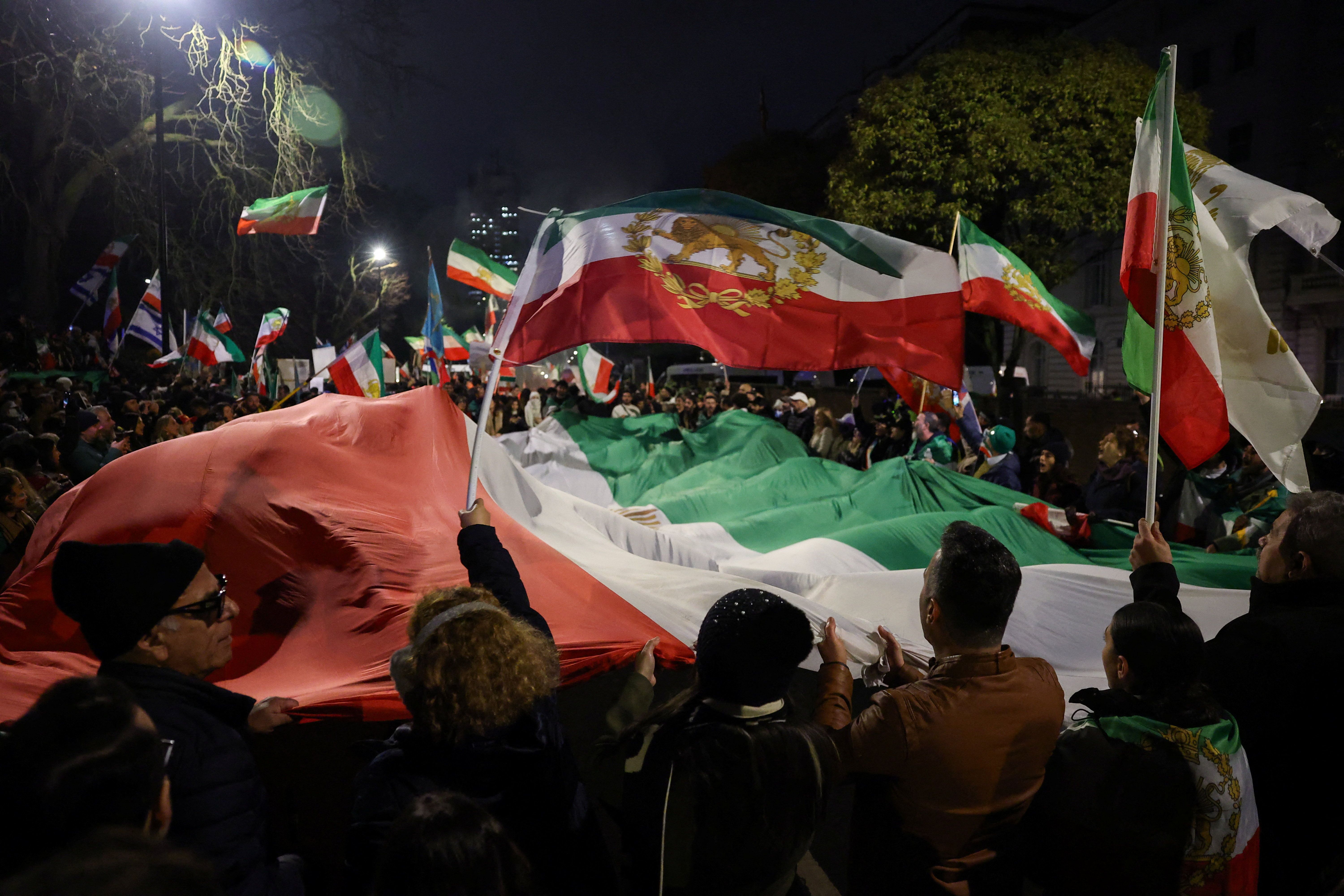 Demonstrators hold a large "Lion and Sun" pre-Islamic Revolution national flag of Iran, during a gathering outside the Iranian embassy in support of nationwide protests in Iran, in London, Britain, January 18, 2026.
