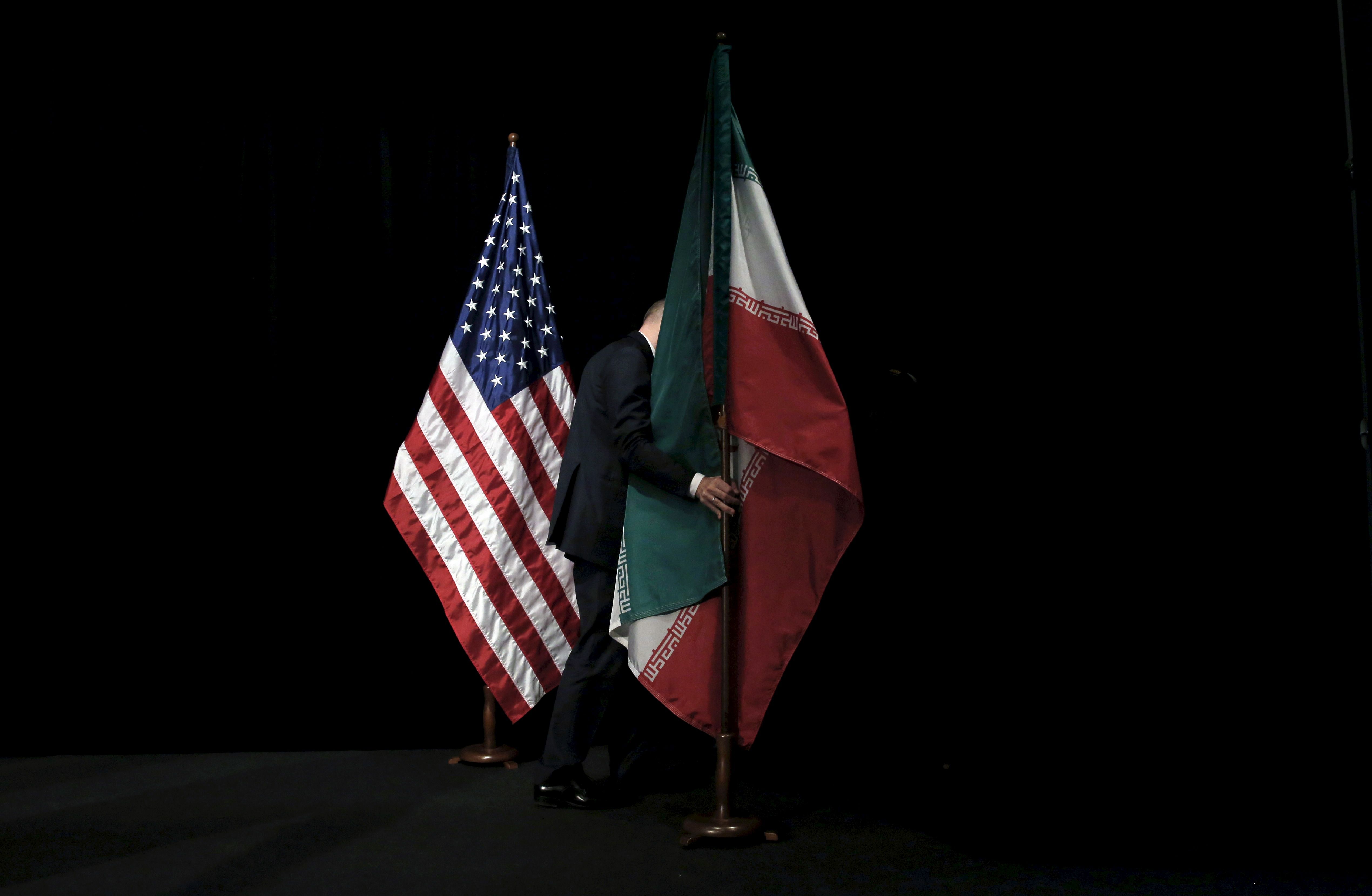  A staff member removes the Iranian flag from the stage after a group picture with foreign ministers and representatives of the U.S., Iran, China, Russia, Britain, Germany, France and the European Union during the Iran nuclear talks at the Vienna International Center in Vienna, Austria July 14, 2015.