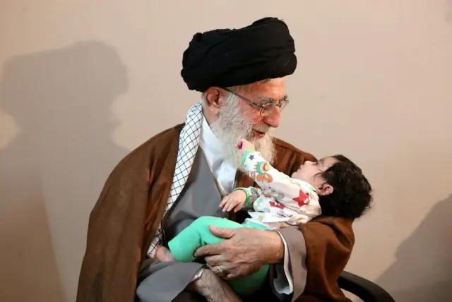 Supreme Leader Ali Khamenei holding a baby (undated)