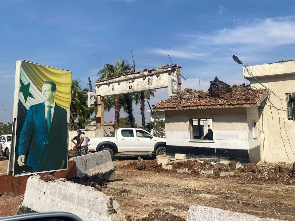 A poster depicting Syria's President Bashar al-Assad is seen at a damaged area in the aftermath of what Syrian state media reported was an Israeli strike in Hama, Syria September 9, 2024. 