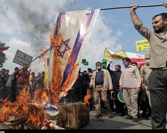 Iranian regime supporters burning an Israeli flag on Quds Day in 2022
