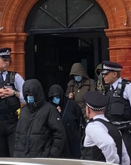 خروج افرادی با سر و صورت پوشیده از سفارت ایران در لندن، در پی تجمع معترضان به اعدام