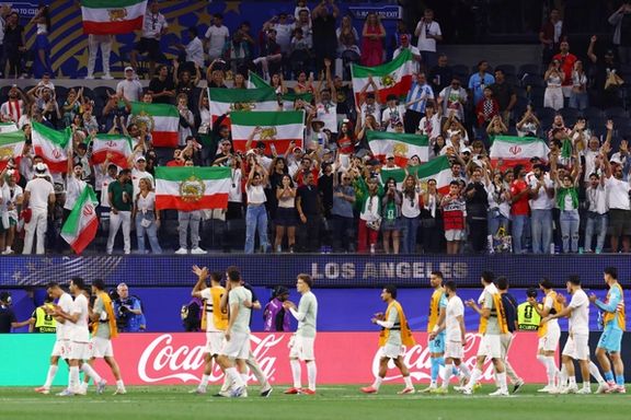 Iran players walk past Iranian fans holding official and pre-revolutionary flags, in Los Angeles, US, June 16, 2026