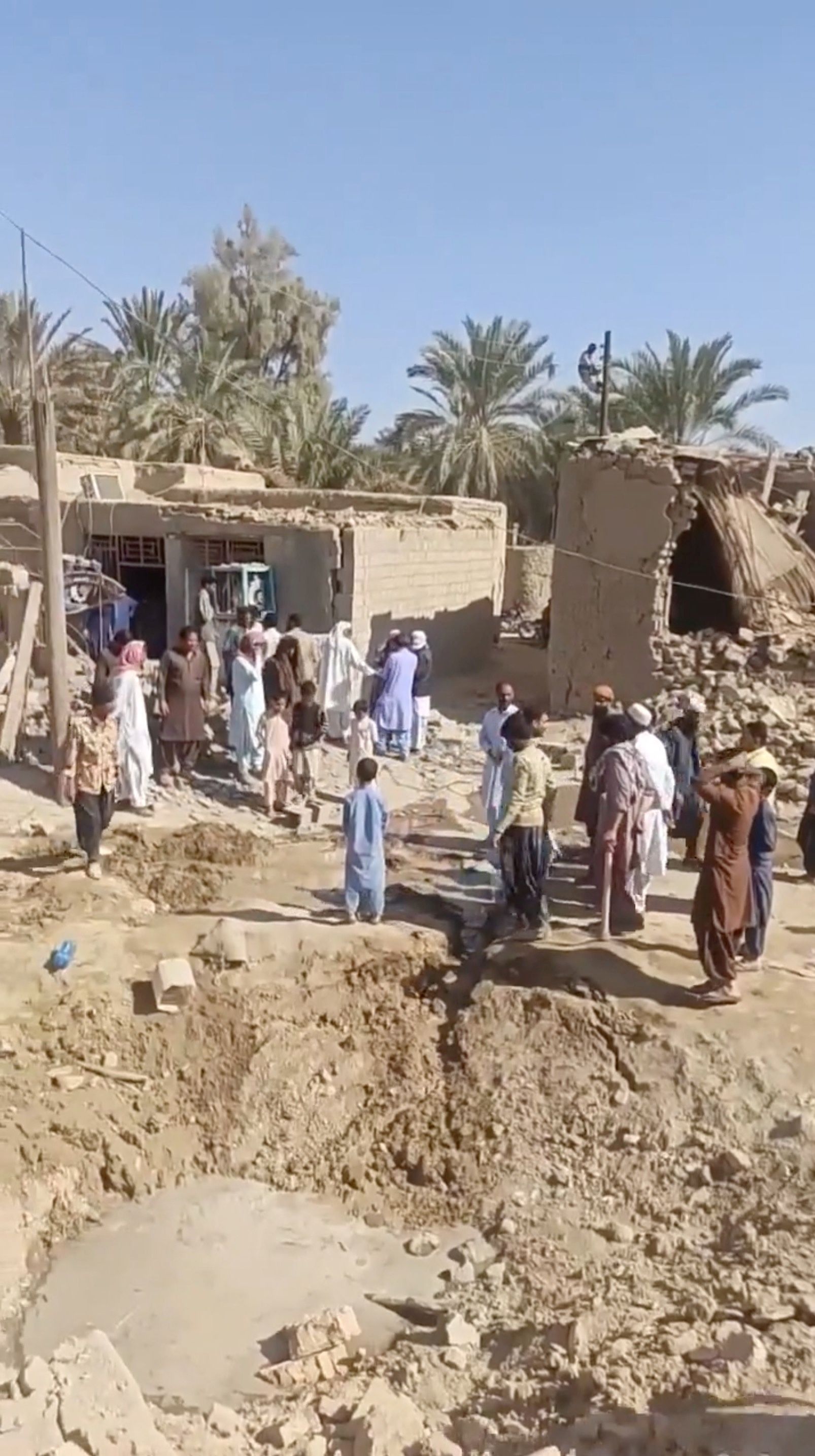 People gather near rubble in the aftermath of Pakistan's military strike on an Iranian village near Saravan, Sistan and Baluchestan Province, Iran, January 18, 2024. 