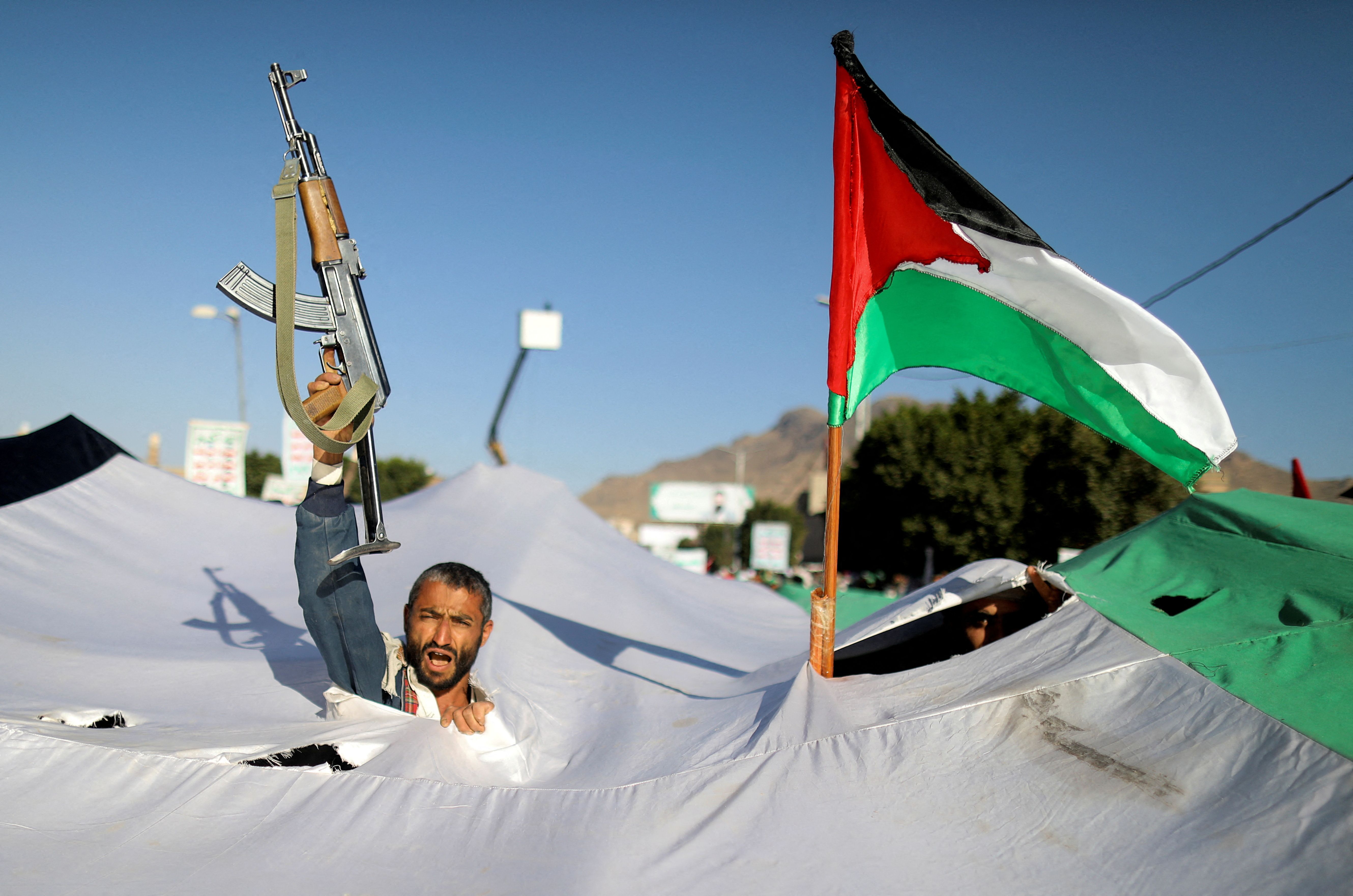 A protester holds a gun, as he takes part in a demonstration in solidarity with Palestinians in the Gaza Strip, amid the ongoing conflict between Israel and the Palestinian Islamist group Hamas, in Sanaa, Yemen December 8, 2023.
