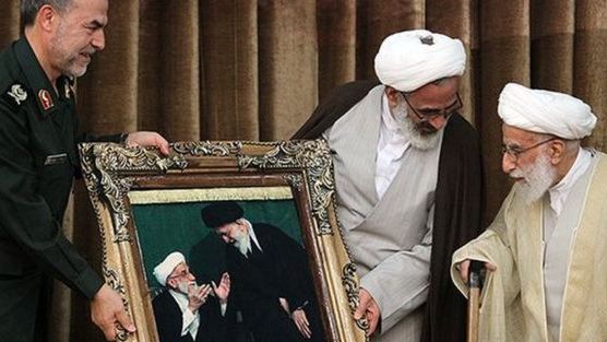 Jannati being presented with a large photo of himself with Khamenei in 2019