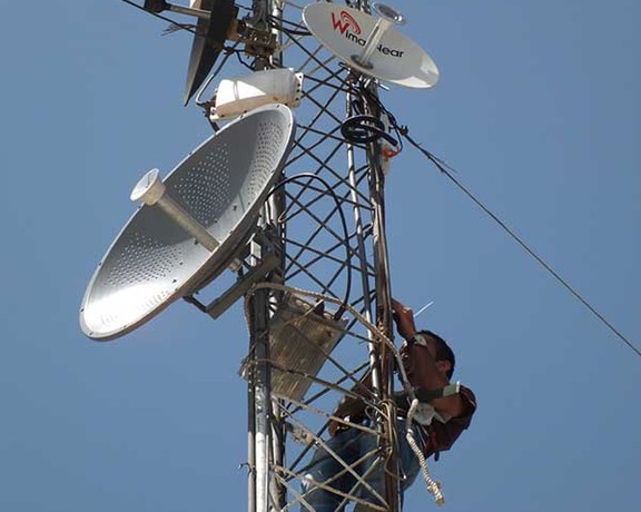 A technician working on an internet tower