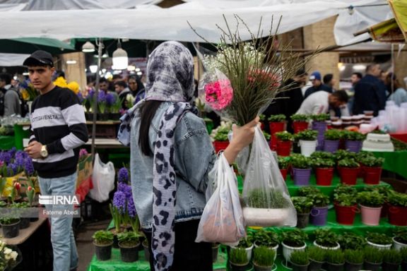 An Iranian woman buying flowers on the eve of Norouz in Tehran, March 19, 2024