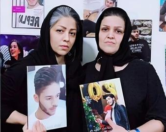 Mahboubeh Ramezani (left) holds a photo of her slain son Pejman Qolipour, alongside Rahimeh Yousefzadeh, who holds a photo of her slain son Navid Behboudi.