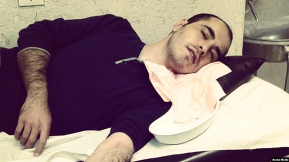 An older photo of Hossein Ronaghi receiving medical help
