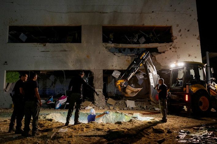 Israeli rescue force members inspect the site where a missile fired from Iran towards Israel hit a school building, in central Israel, October 1, 2024
