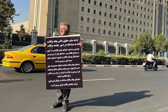 مهدی کریمی فارسی، وکیل دادگستری در اعتراض به قوانین علیه وکلا با یک پلاکارد مقابل مجلس رفت