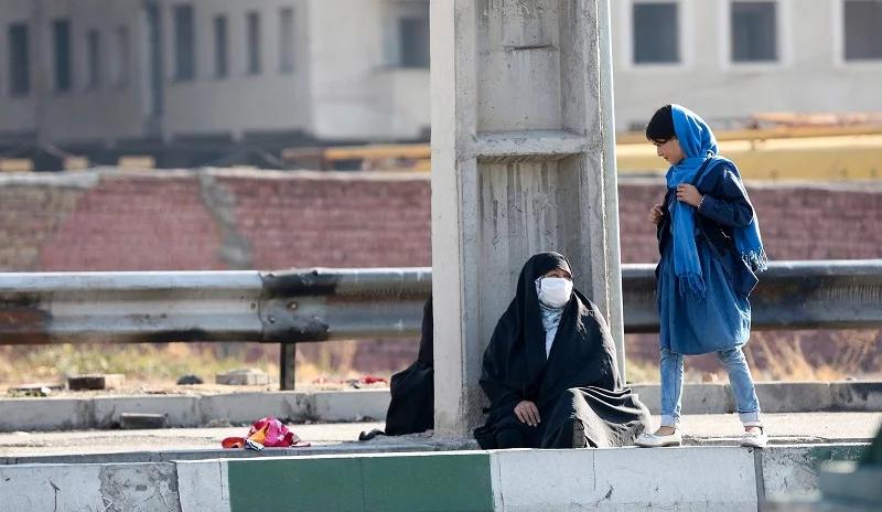 An Iranian woman begging for money on a street in Tehran 