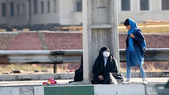 An Iranian woman begging for money on a street in Tehran