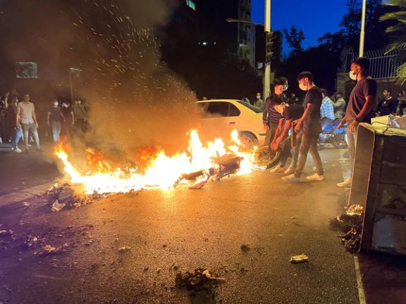 A police motorcycle burns during a protest over the death of Mahsa Amini, a woman who died after being arrested by the Islamic republic's "morality police", in Tehran, Iran September 19, 2022