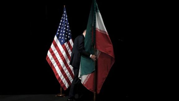 A staff member removes the Iranian flag from the stage after a group picture with foreign ministers and representatives during the Iran nuclear talks at the Vienna International Center in Vienna, Austria July 14, 2015.