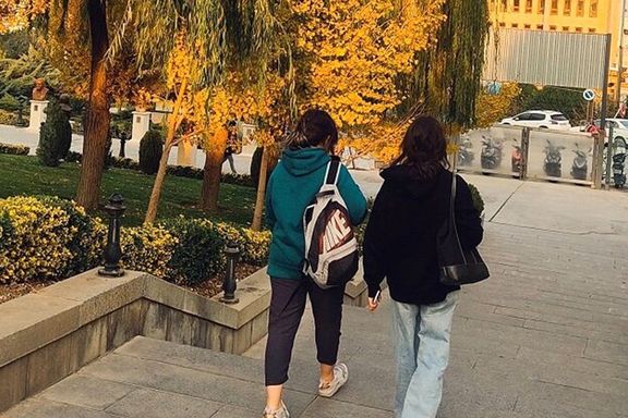 Two young woman strolling in a park without covering their hairs