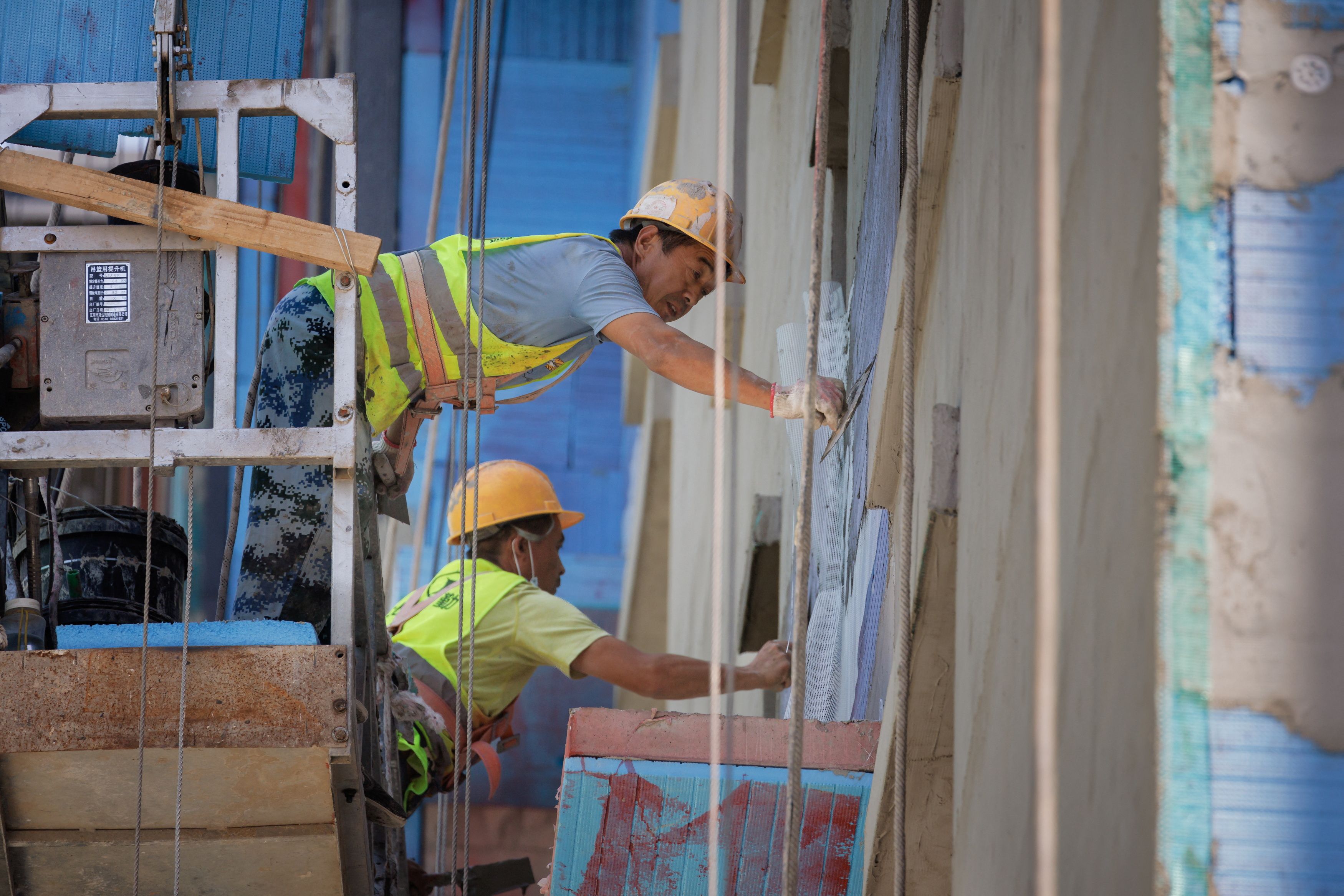 Men work at a construction site of apartment buildings in Beijing, China, July 15, 2022.