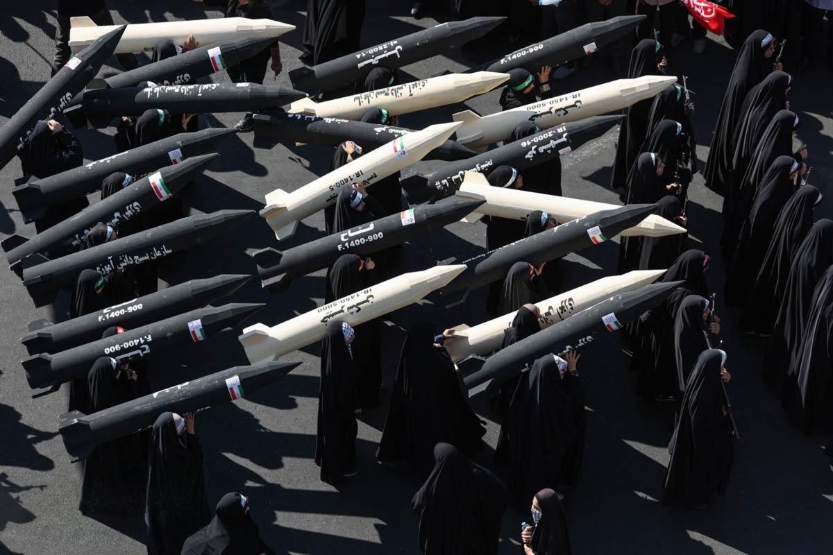 Women carry models of Iranian missiles during a public procession in Iran.