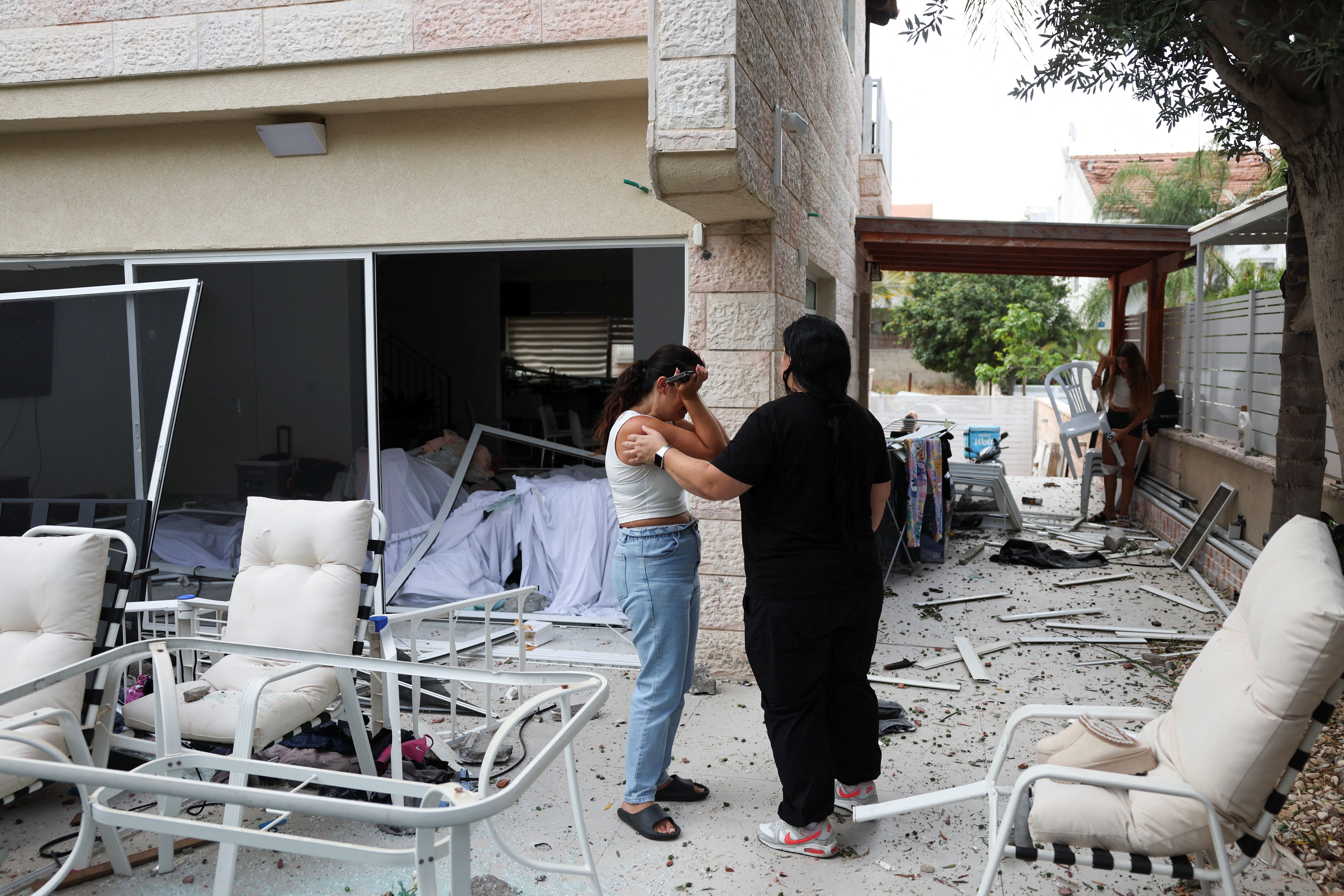 A woman reacts as she stands inside a damaged house at an impact site following missile attack from Iran on Israel, in Rishon LeZion, Israel, June 14, 2025. 