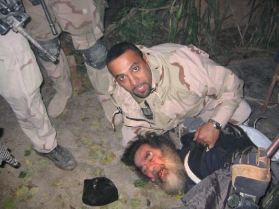 Iraqi-American translator Samir pinning deposed Iraqi leader Saddam Hussein to the ground during his capture in Tikrit, December 13, 2003