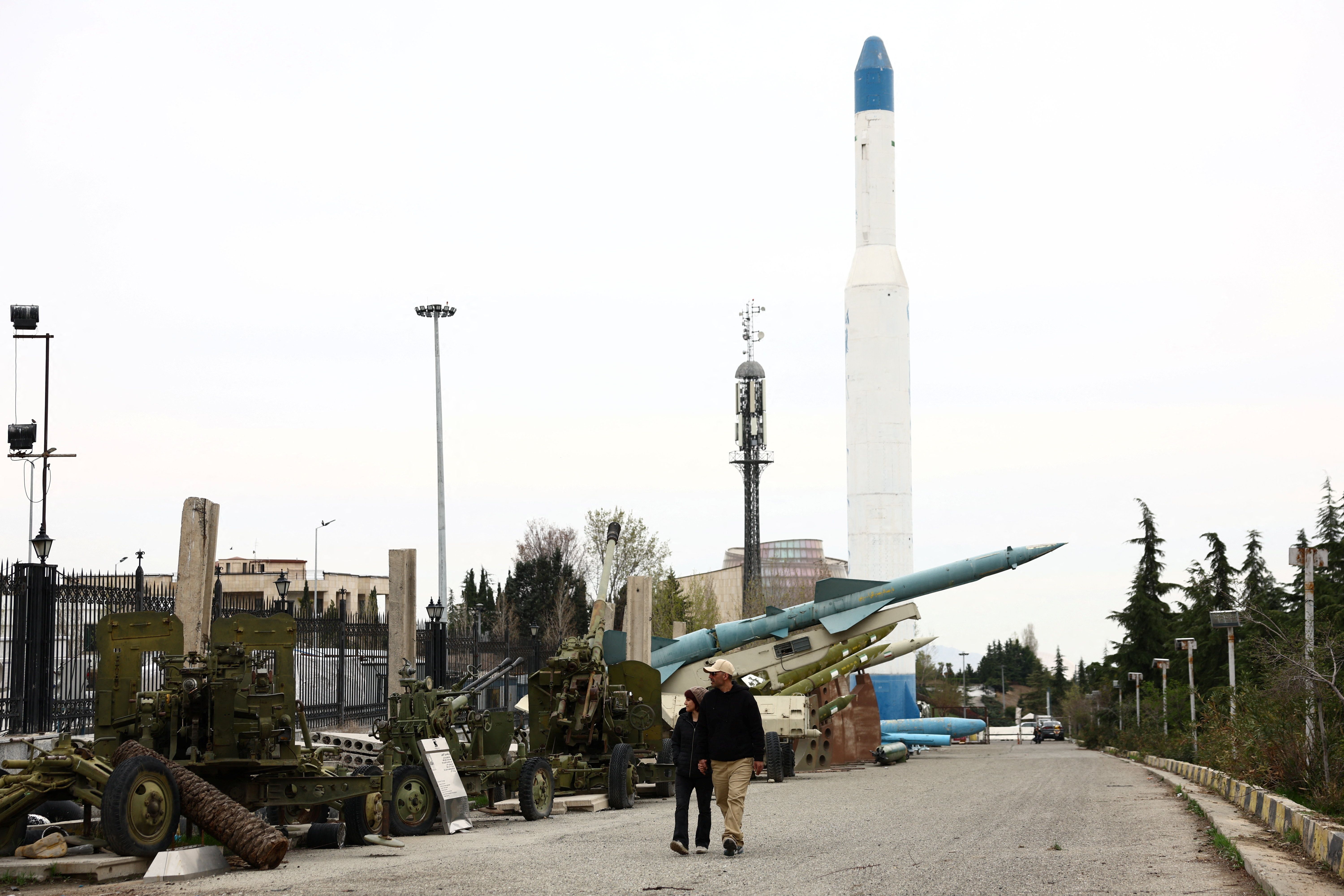 An Iranian couple walks near Iranian missiles in a park in Tehran, March 26, 2026.