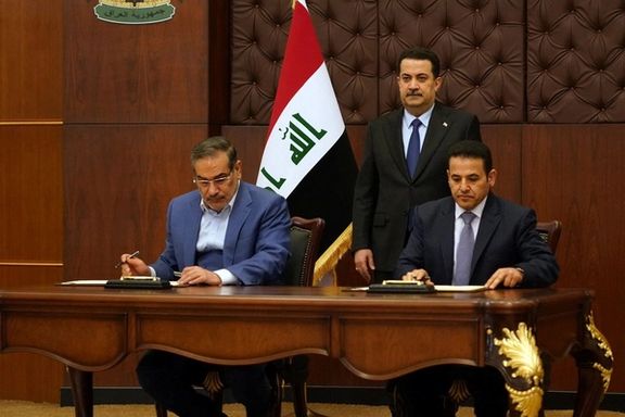 Iraqi Prime Minister Mohammed Shia al-Sudani looks on as Iraq's National Security Adviser Qasim al-Araji and Iran's Supreme National Security Council secretary Ali Shamkhani sign a security agreement, in Baghdad, March 19, 2023