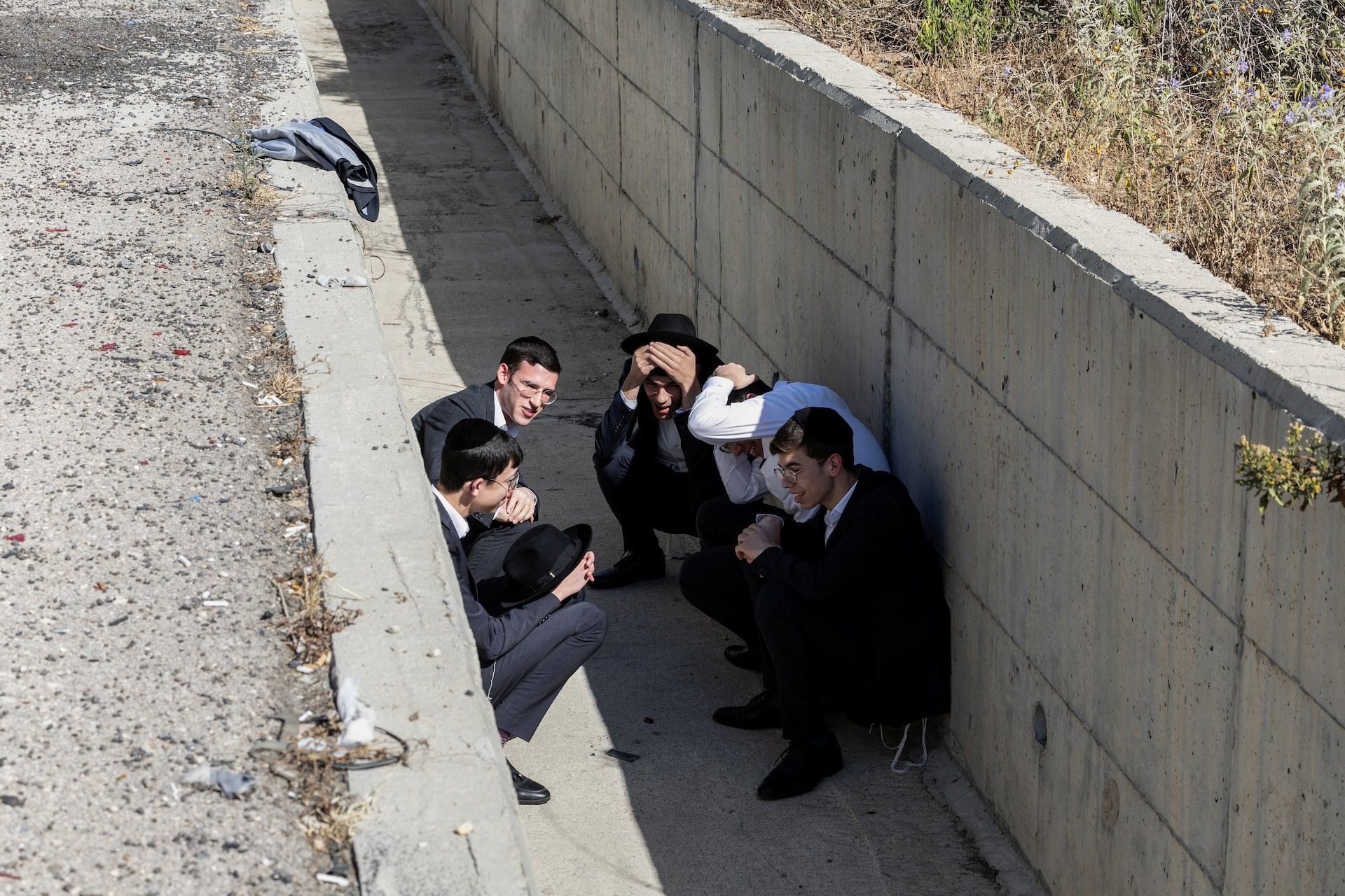 Israelis take shelter at the side of a highway as siren sounds following missile attack from Iran on Israel, in central Israel June 15, 2025. 