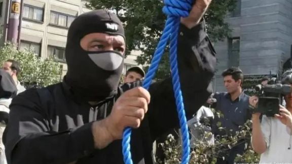 A masked executioner prepares a noose for a public hanging in Iran (Undated)